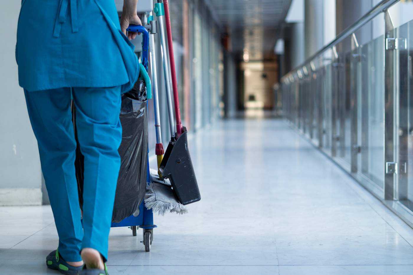 Woman Pushing A Cleaning Cart