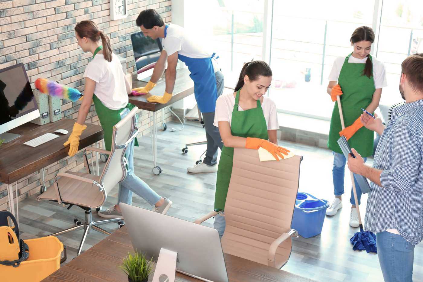 Cleaning Team Dusting And Mopping An Office