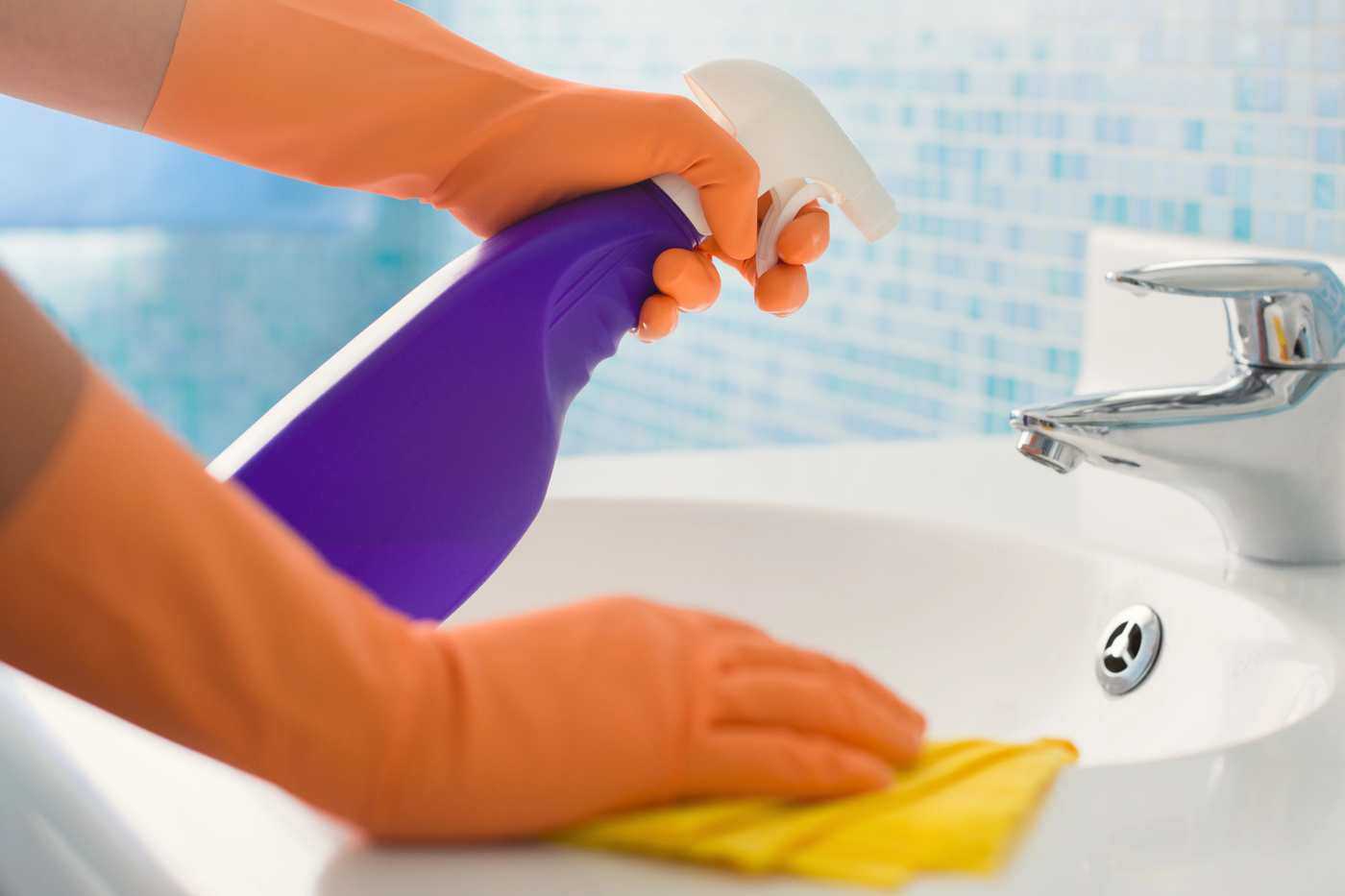 Woman Wearing Orange Gloves Cleaning A Bathroom Sink