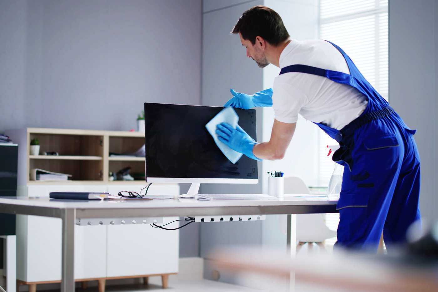 Man Cleaning Computer In An Office