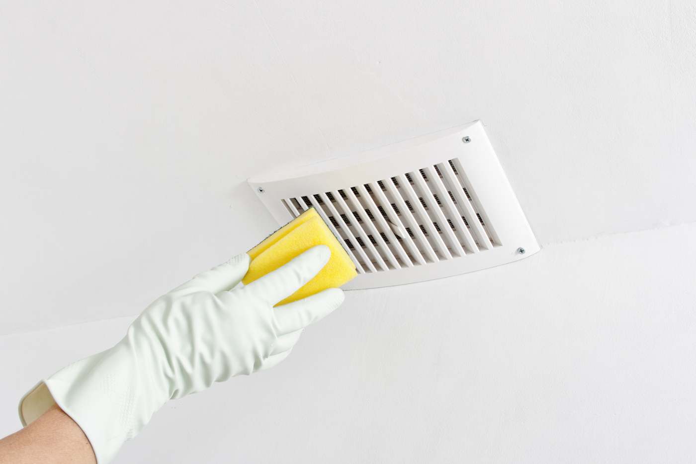 Person Cleaning Ceiling Air Vent Person Cleaning Ceiling Air Vent