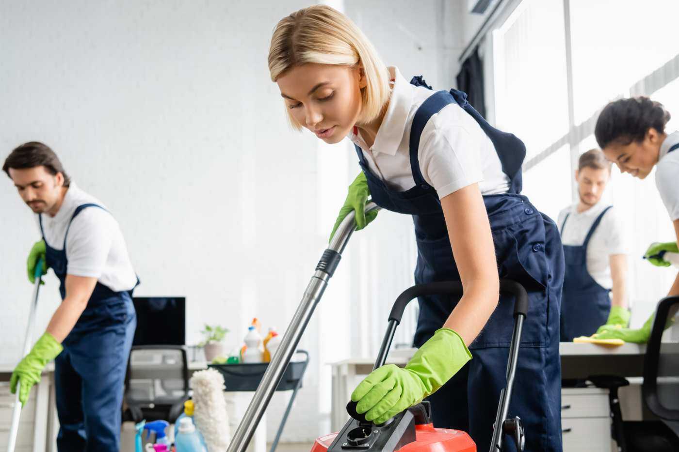 Team Of Office Cleaners Vacuuming An Office