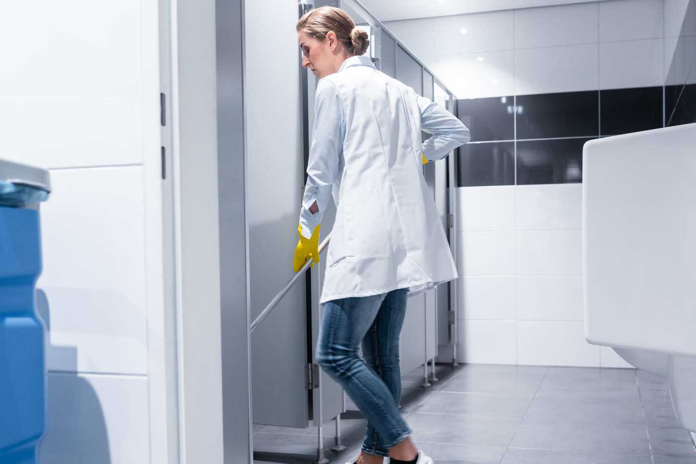 Woman Mopping Commercial Bathroom