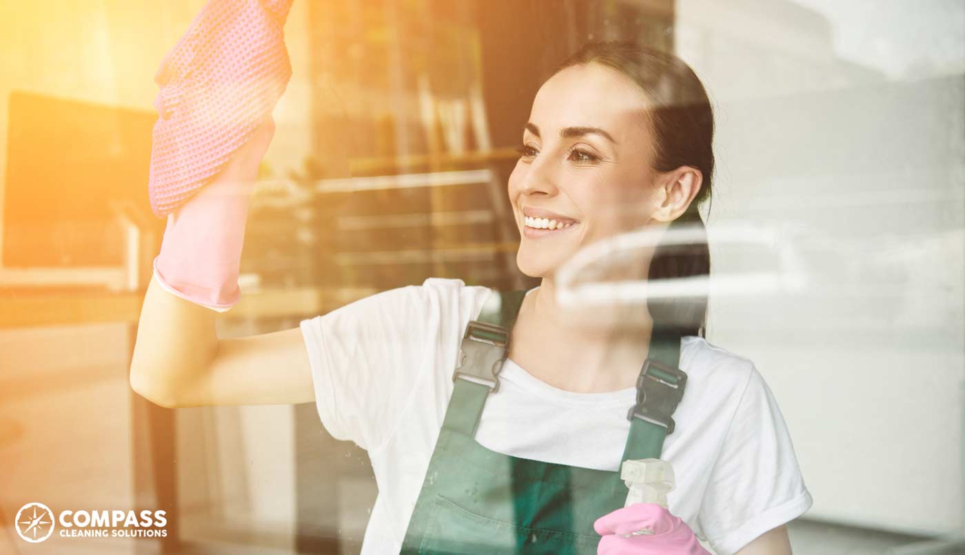 Woman Cleaning Window in Commercial Office Building